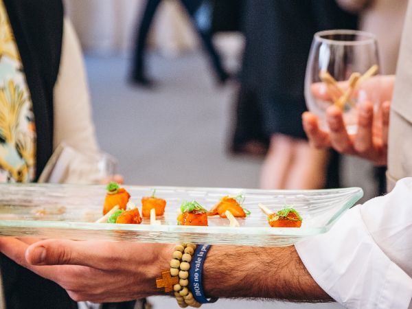 Bandeja de aperitivos con brochetas de verdura y albahaca servidos en coffee break de evento gastronómico
